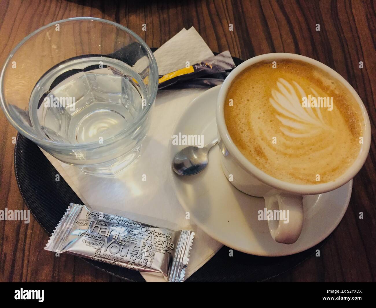 Cup of coffee and a glass of water. Traditional way of serving cappuccino in Bratislava, Slovakia. - Smartphone Captured Stock Image