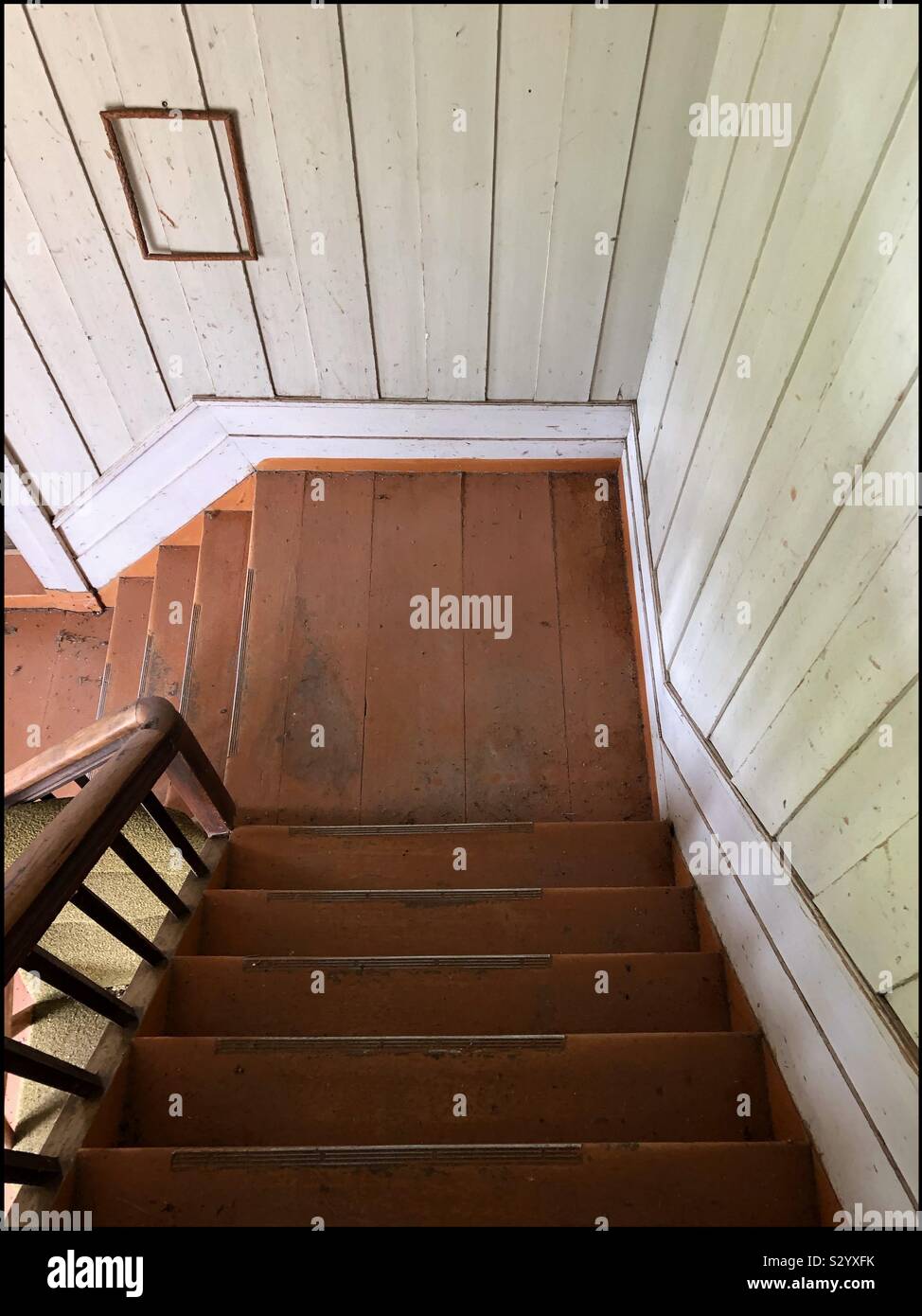 Looking down the staircase in an old abandoned farmhouse which has been empty since 1971. - Smartphone Captured Stock Image