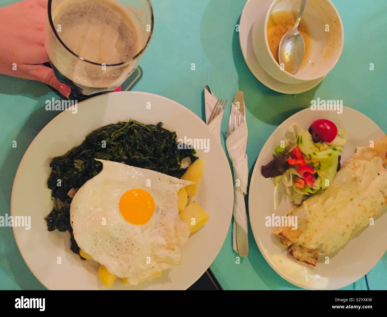 Healthy food on the table in Europe. Spinach, potatoes, egg and potato pancake. - Smartphone Captured Stock Image