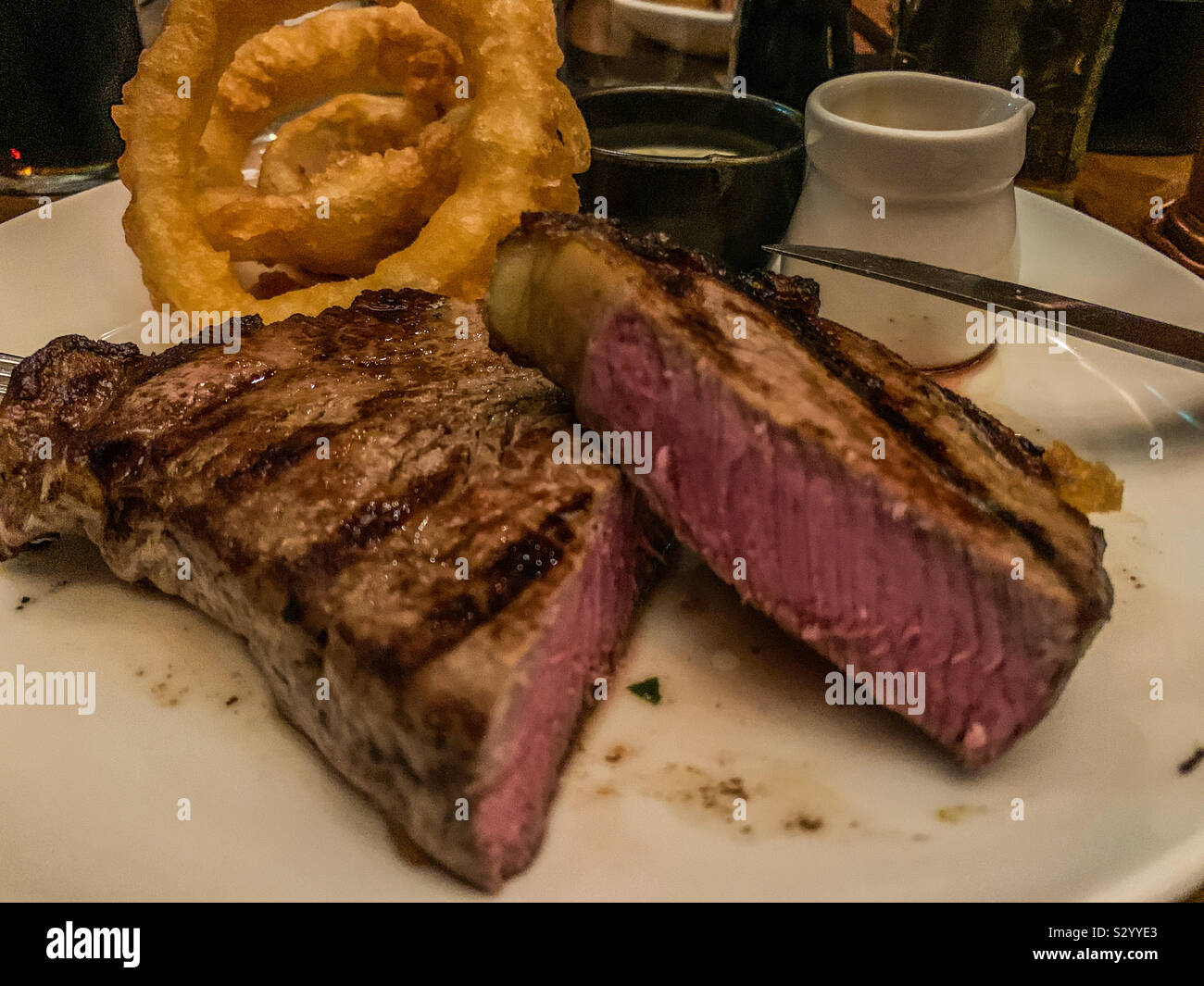 Medium Rare sirloin steak and onion rings Stock Photo