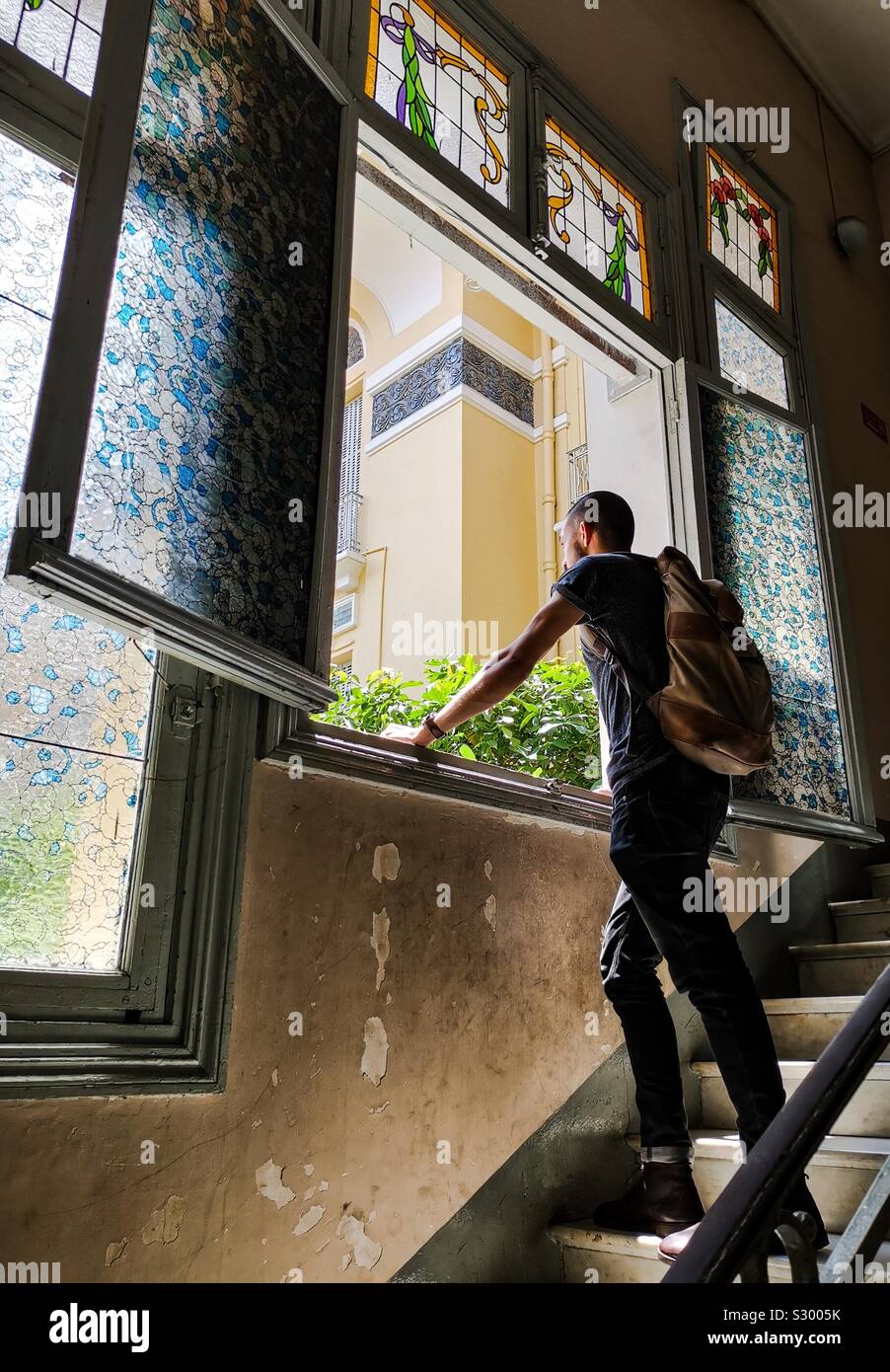 Man looking out window at Fine Art museum, Vietnam Stock Photo
