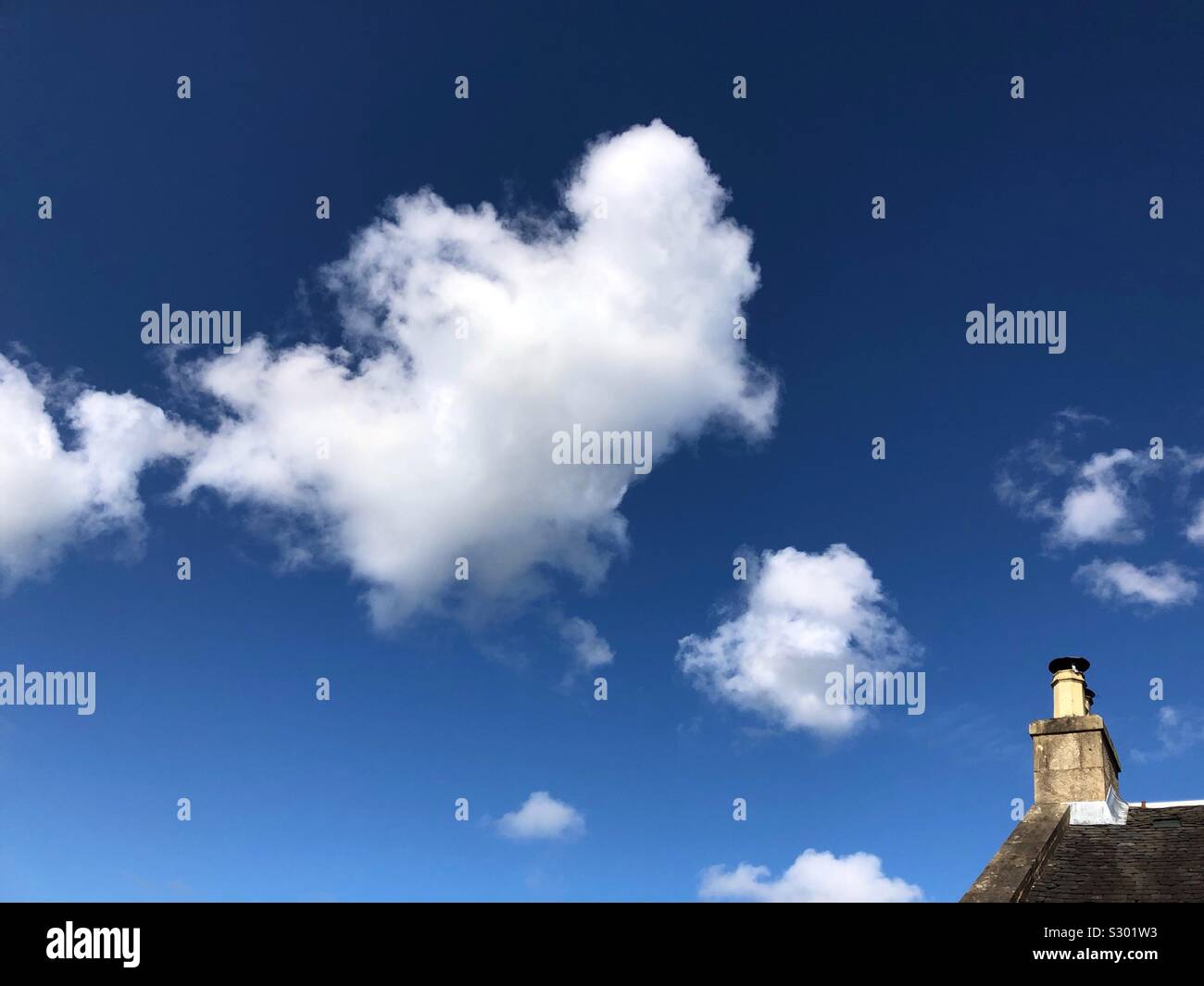 Chimney and fluffy cumulus clouds - Smartphone Captured Stock Image