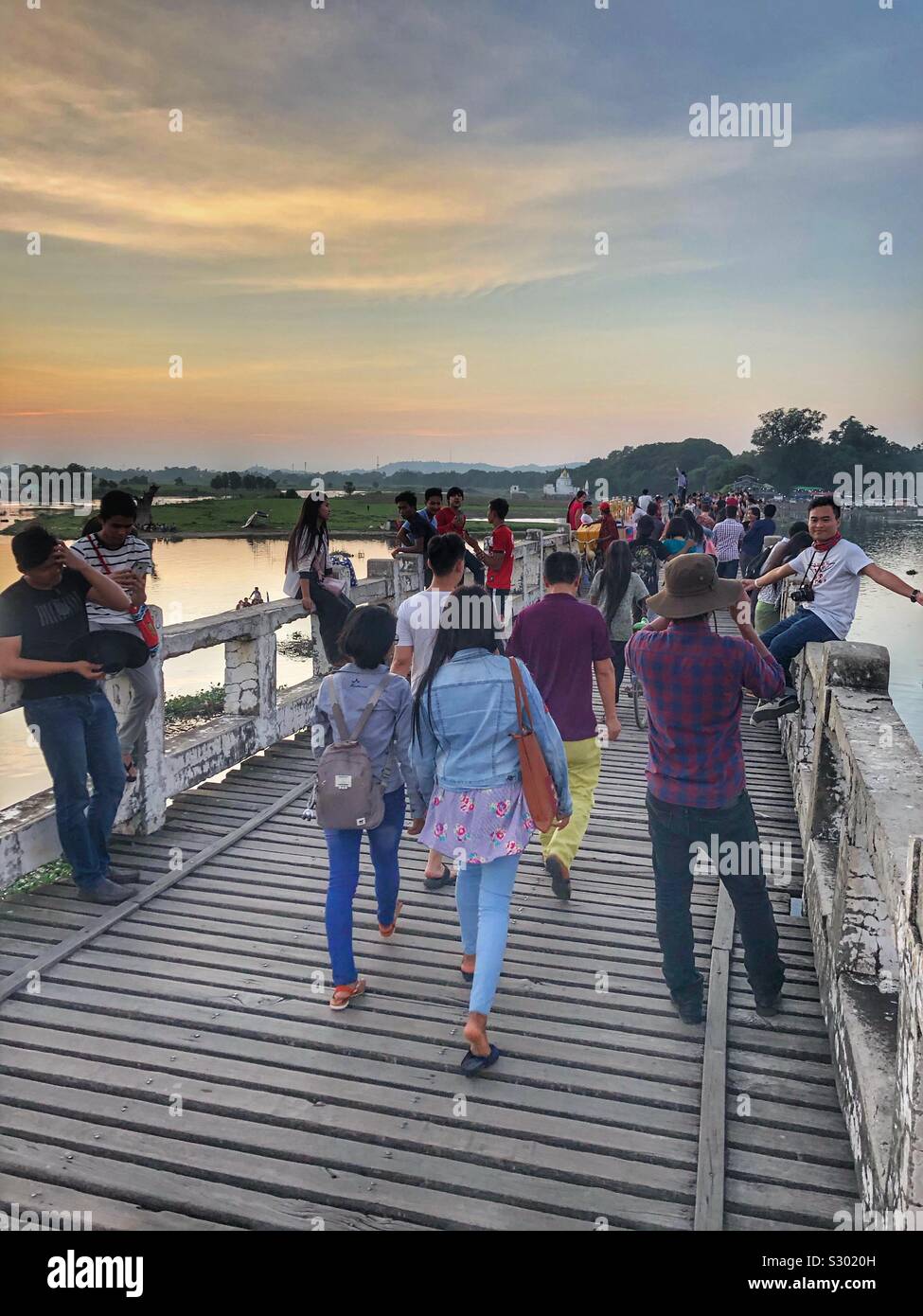 People enjoying the local U Bein Bridge in Mandalay, Myanmar. Stock Photo
