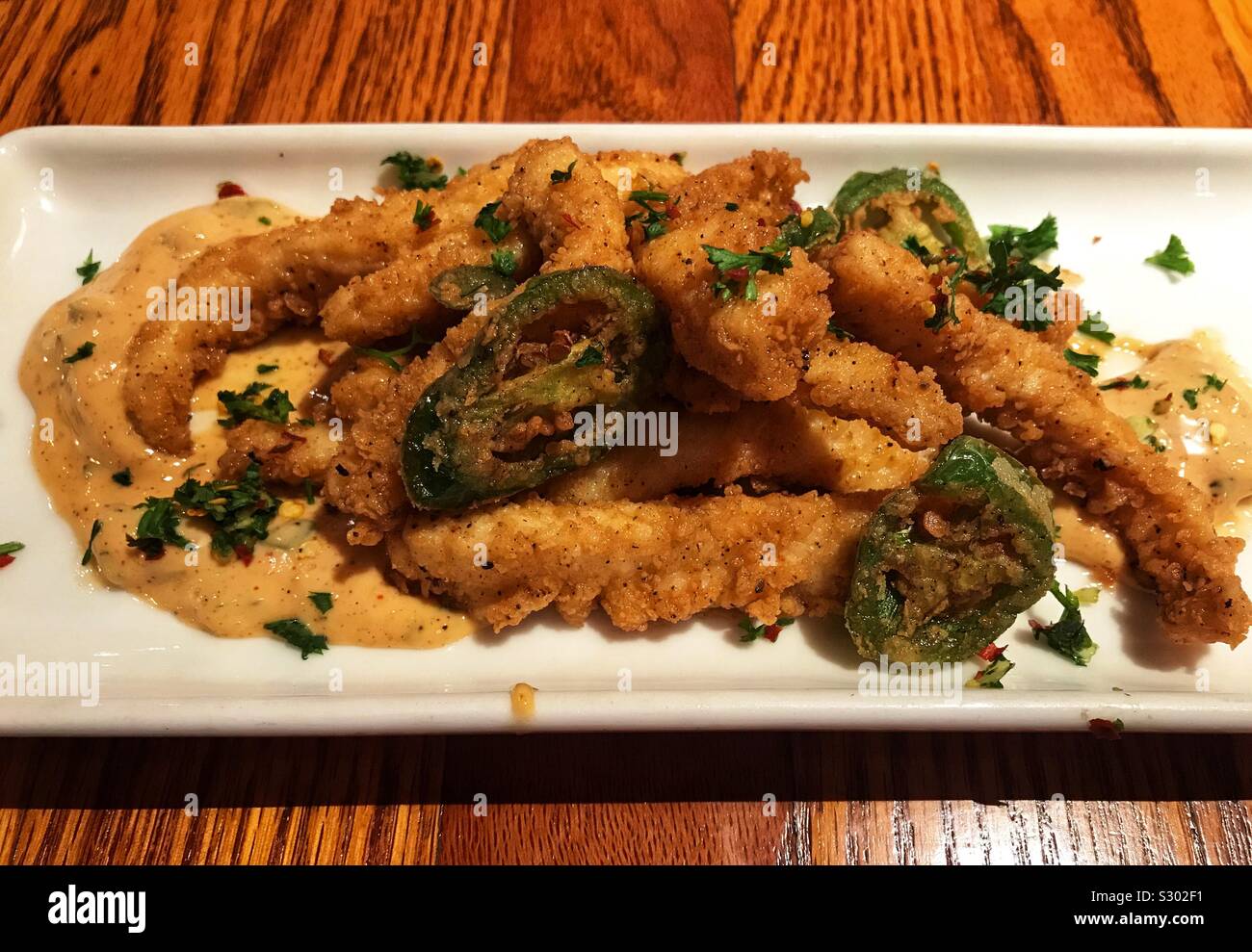 Fried Calamari with jalapeño peppers and aioli sauce Stock Photo Alamy