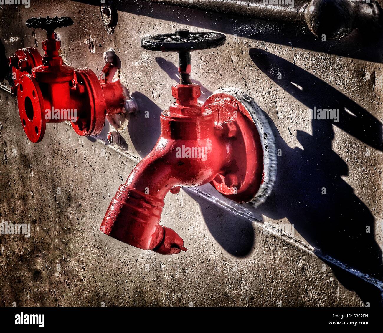 Wall mounted red painted water taps , Scotland, UK - Smartphone Captured Stock Image