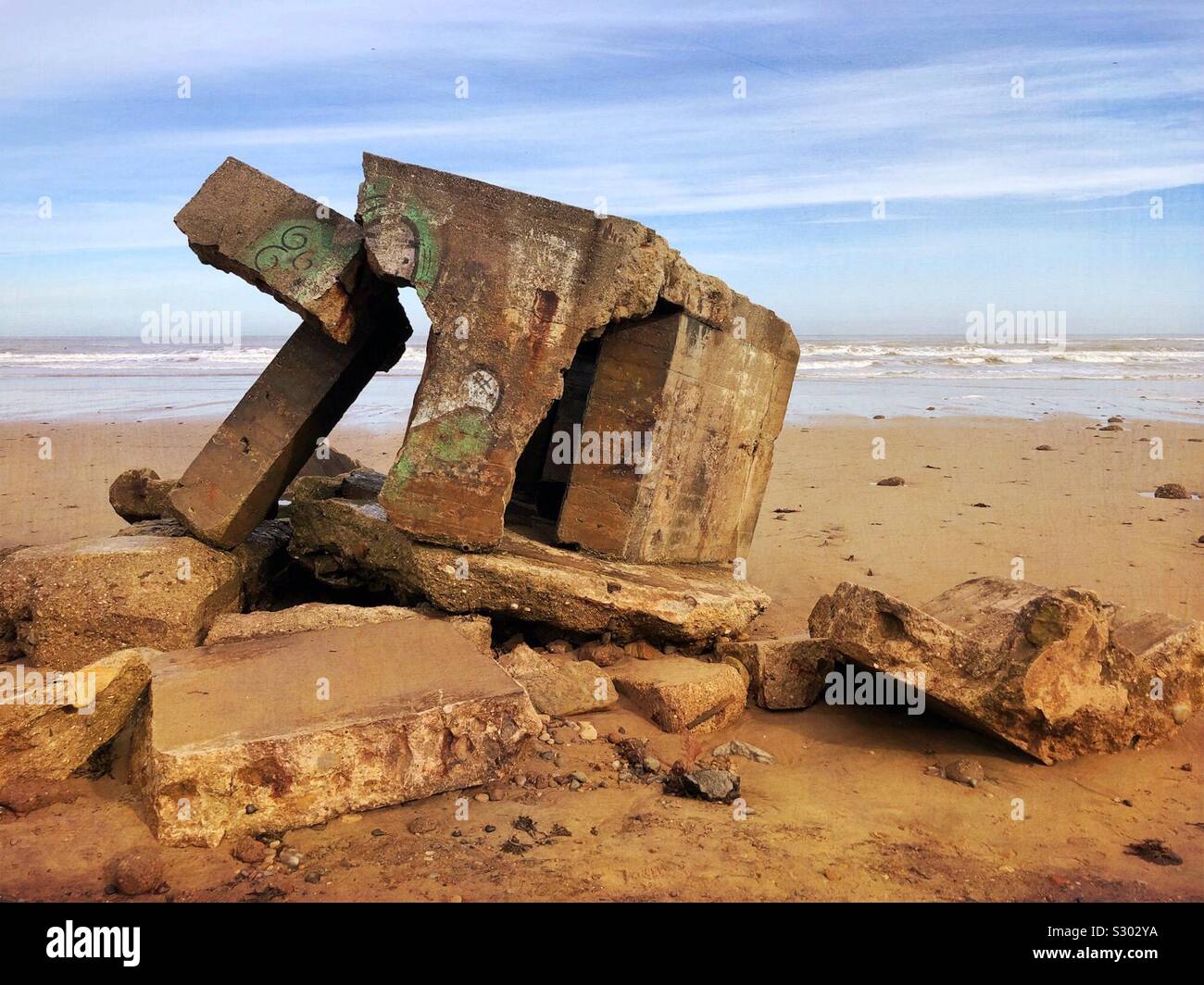 Remains of a WW2 concrete pillbox breaking up on the beach at Cayton Bay, North Yorkshire, UK. Stock Photo