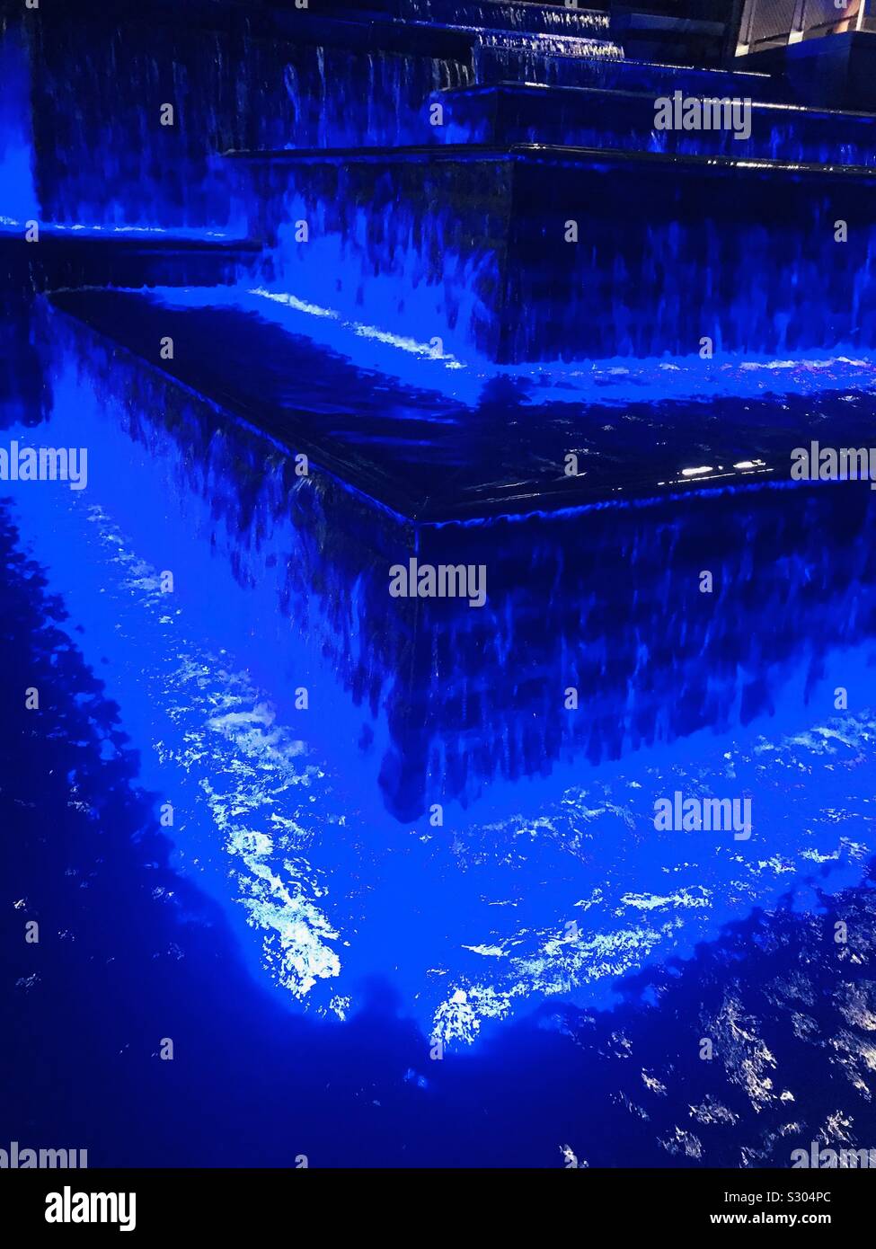 Blue LED water fountain in Jewel Changi Airport, Decorative light shining through water ripples Stock Photo