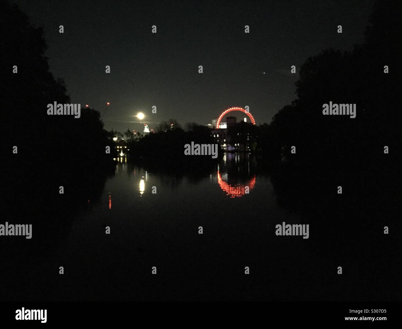 Saint James’s park when dark. Full moon and London eye overlooking the park. Walking through the park in central London on the way to the station of the underground. - Smartphone Captured Stock Image