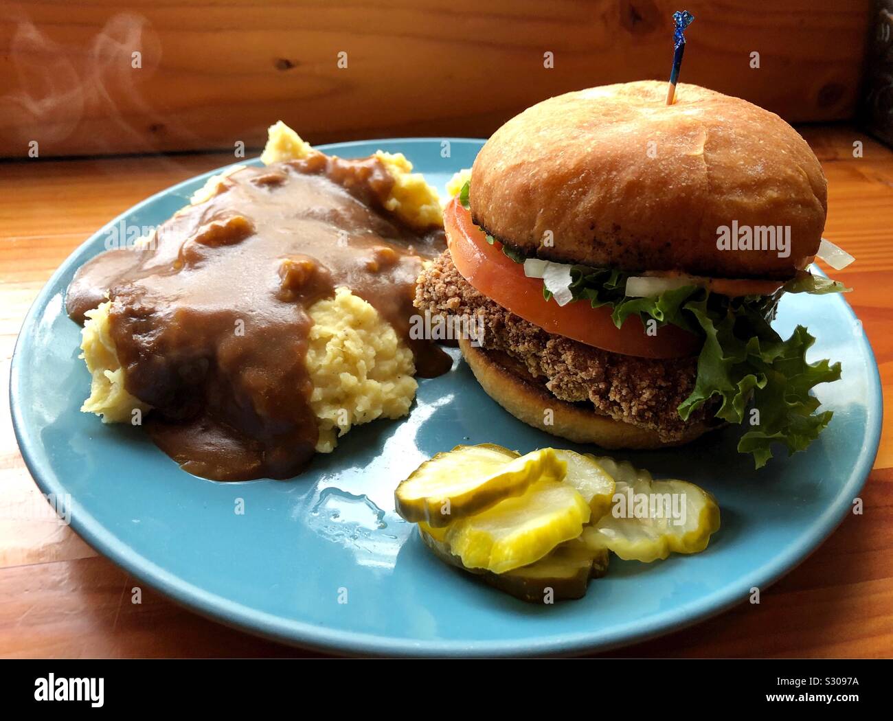 A vegan meal of tofu “chicken” sandwich with mashed potatoes and gravy. Stock Photo