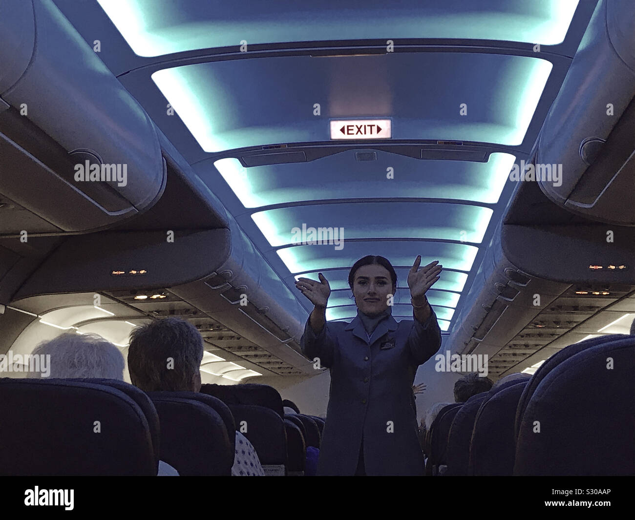 Cabin crew demonstrating how to find the exits on an Aer Lingus flight - Smartphone Captured Stock Image