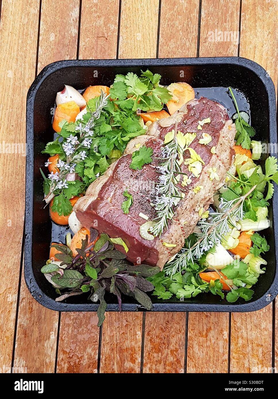 Organic roast beef with fresh vegetables and seasoning. Joint of meat