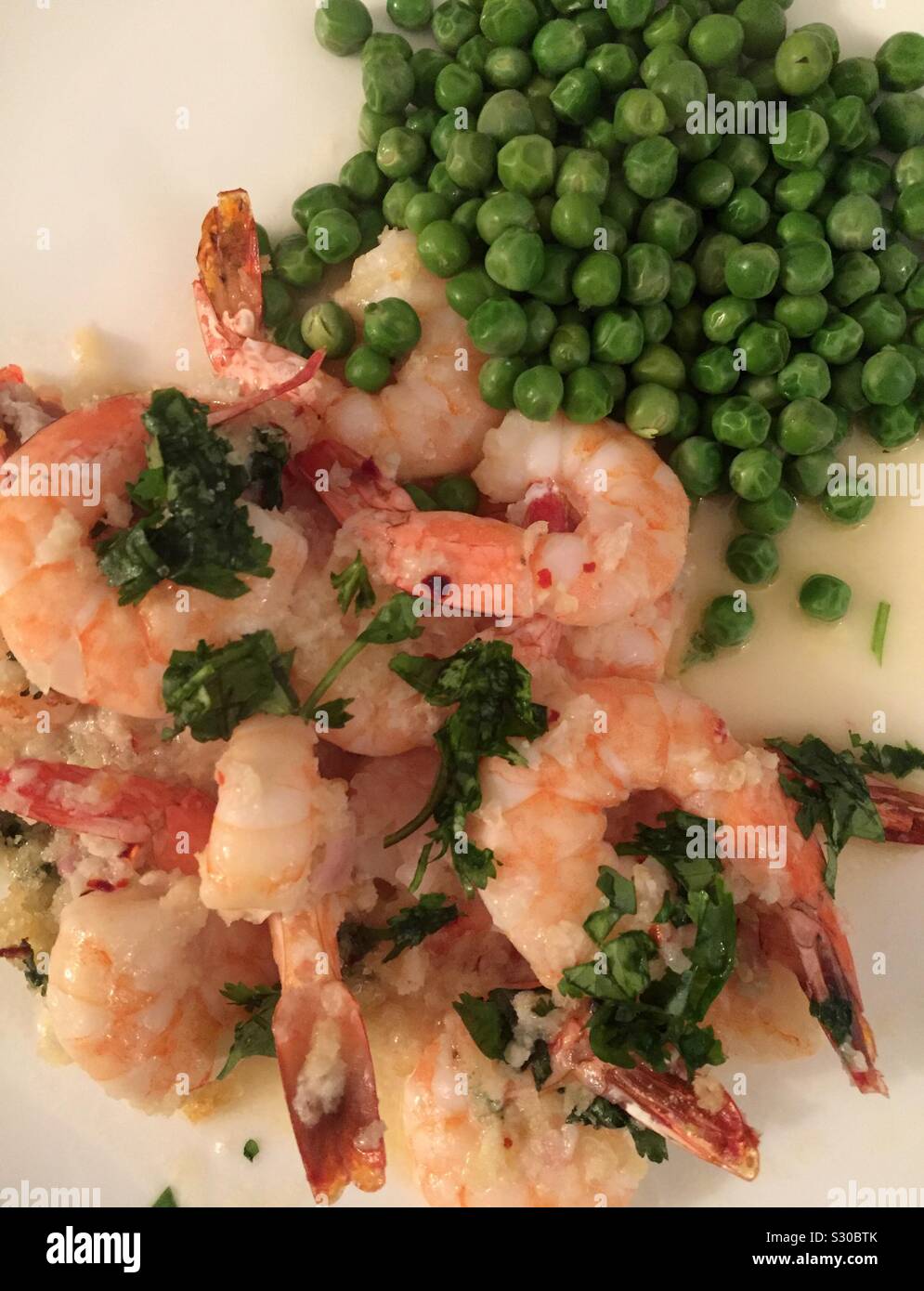 Panko encrusted shrimp scampi with fresh peas form a gourmet entrée