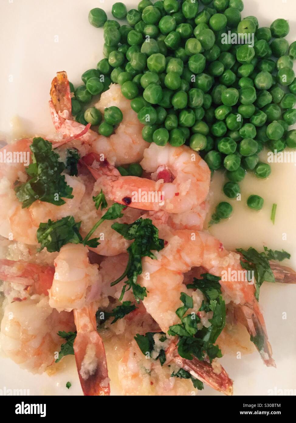 Panko encrusted shrimp entrée with a side of fresh green peas - Smartphone Captured Stock Image