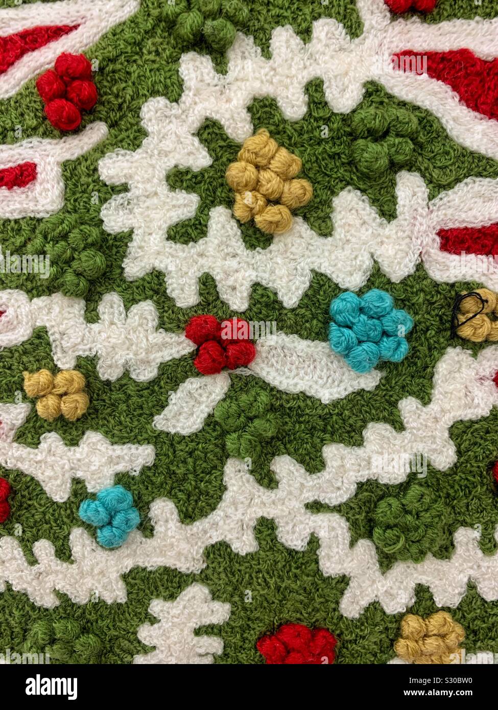 Elaborate Christmas embroidery of a Christmas tree decorated with snow and baubles - Smartphone Captured Stock Image