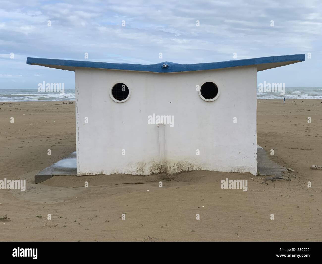 Empty beach view through a bathing boxes eyes - Smartphone Captured Stock Image