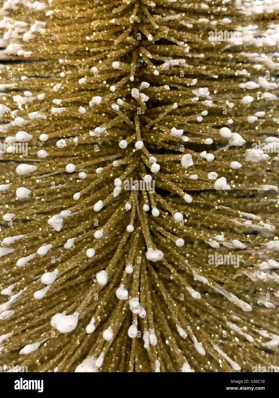 Closeup of a decorative gold Christmas pine tree with dabbles of snow - Smartphone Captured Stock Image