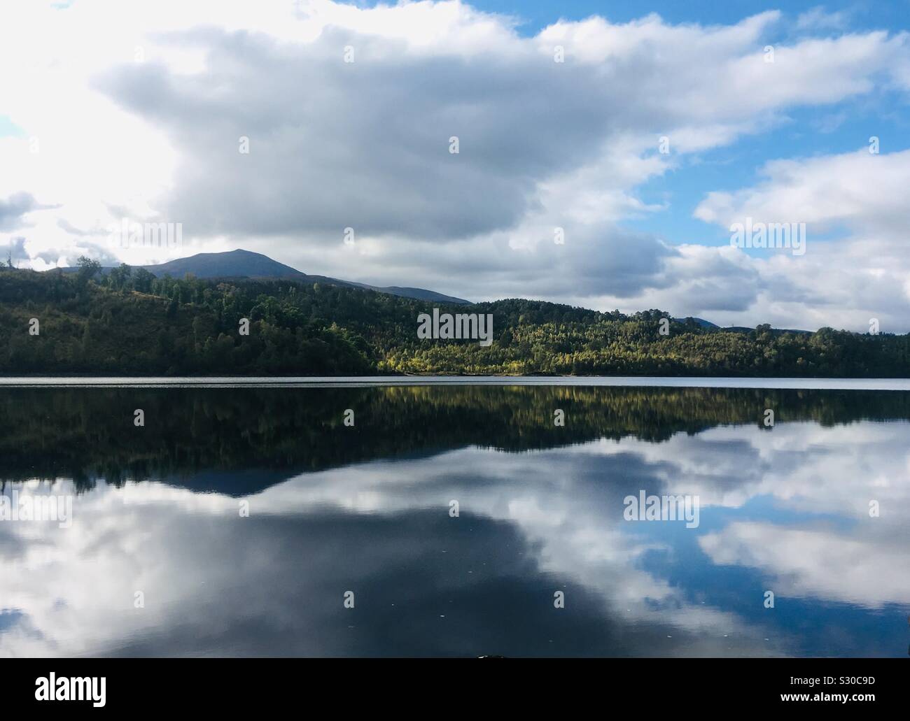 Reflections in Loch Garry from the shoreline, Scottish Highlands Stock Photo