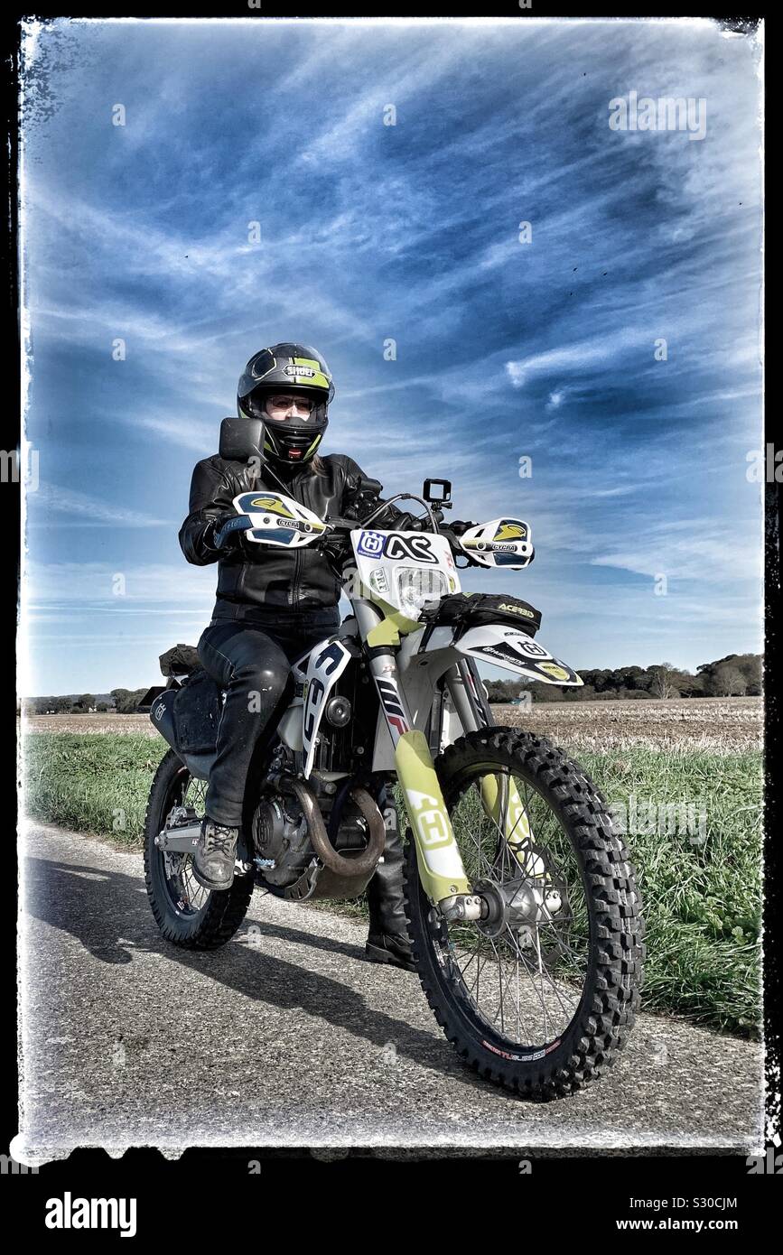 Female motorcyclist riding Husqvarna off road enduro motorcycle Stock Photo