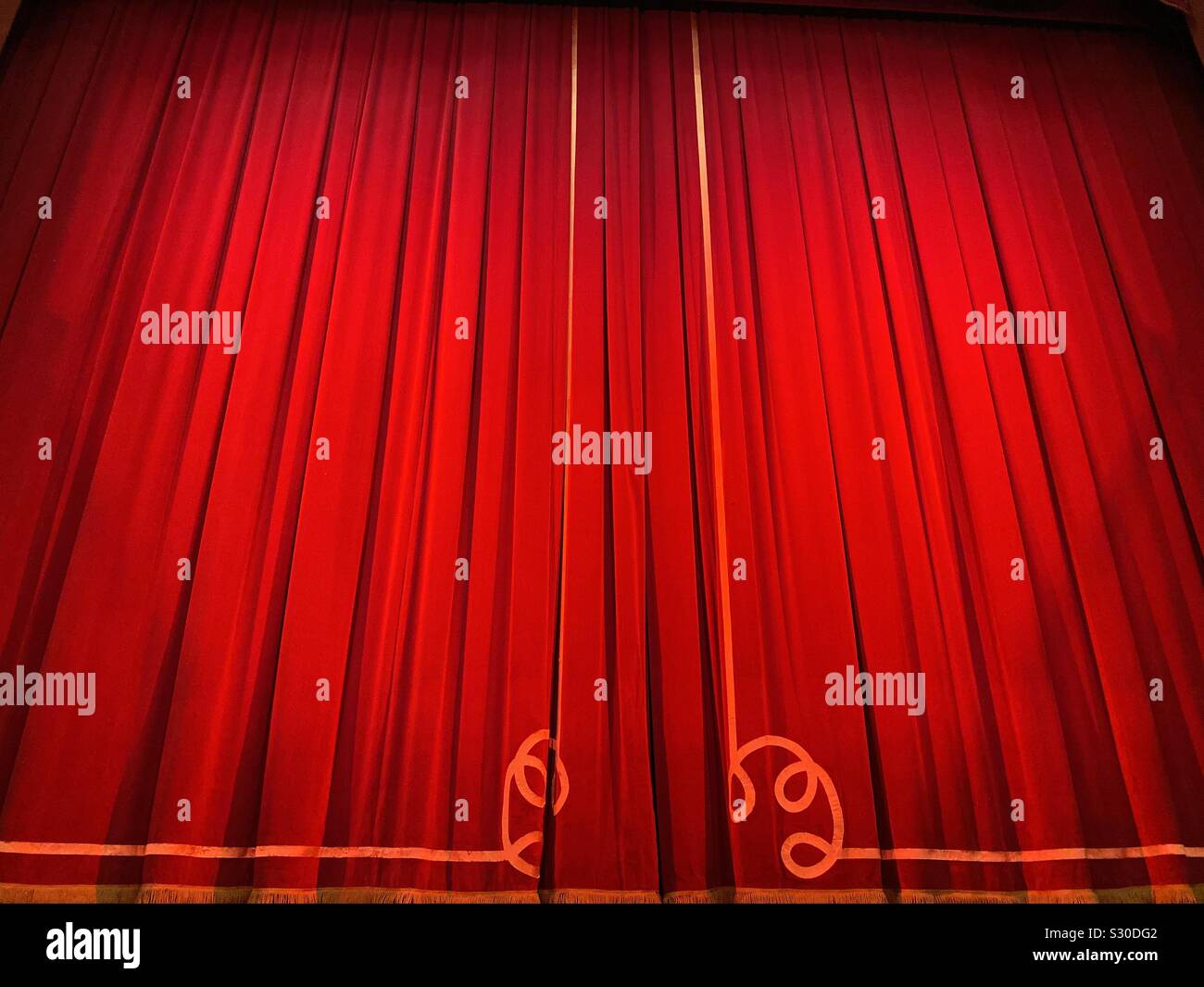 Curtains closed on a theatre stage before the start of a performance - Smartphone Captured Stock Image