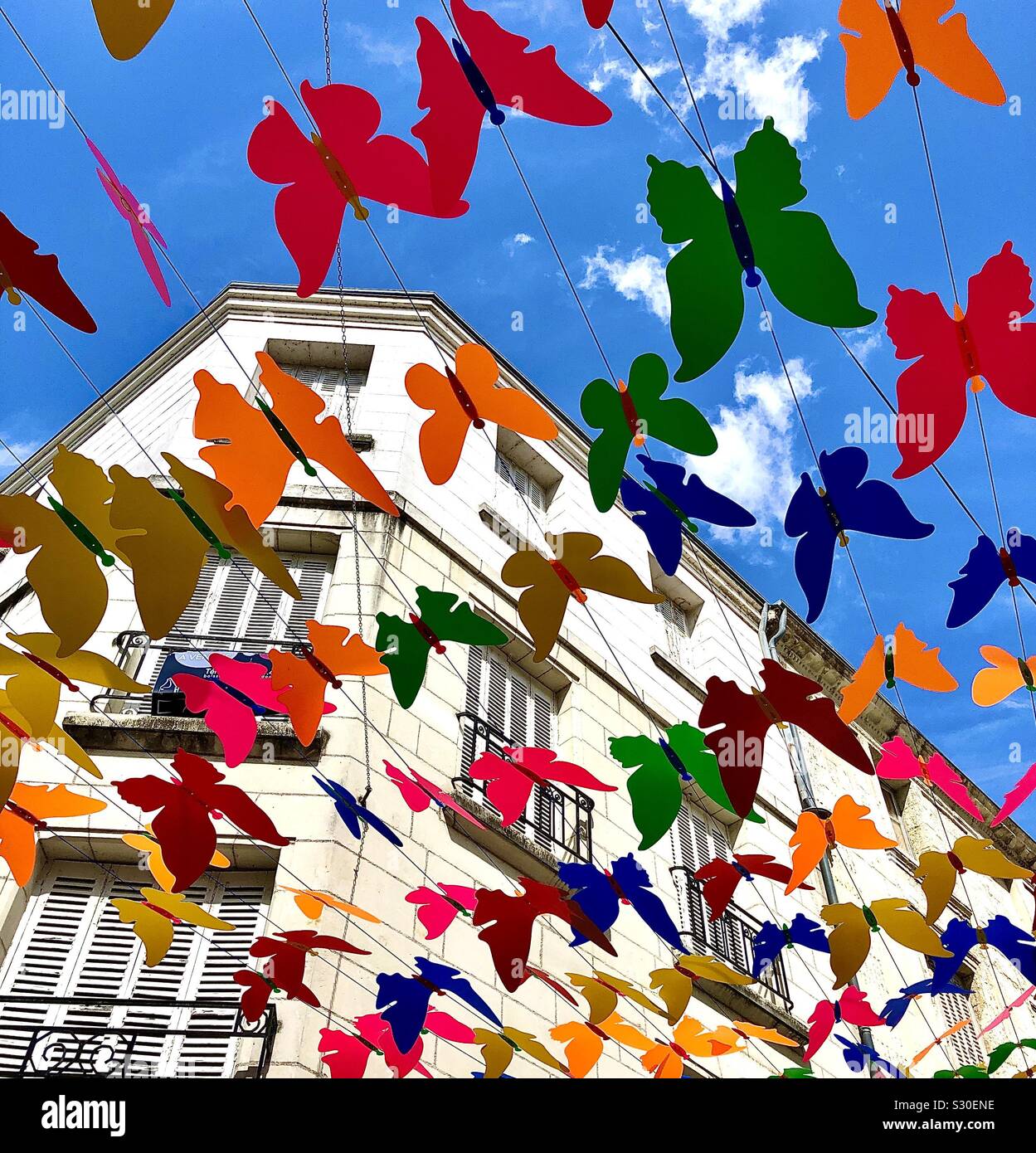 Colourful butterfly decorations above street, Chatellerault, France. - Smartphone Captured Stock Image
