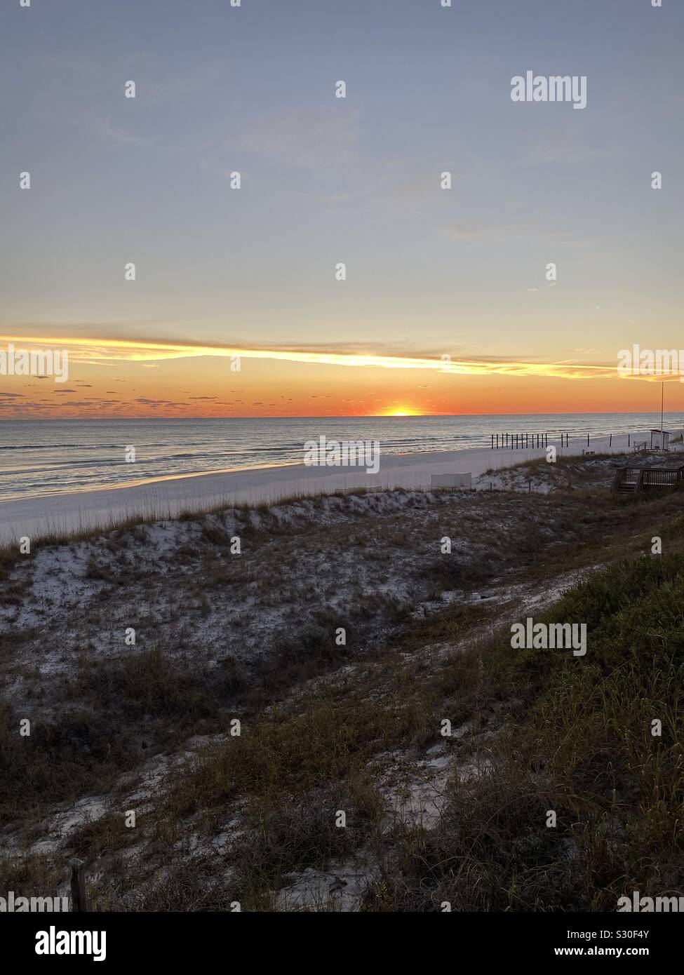 Beach sunset with view of Gulf of Mexico water, sand dunes in Destin, Florida Stock Photo