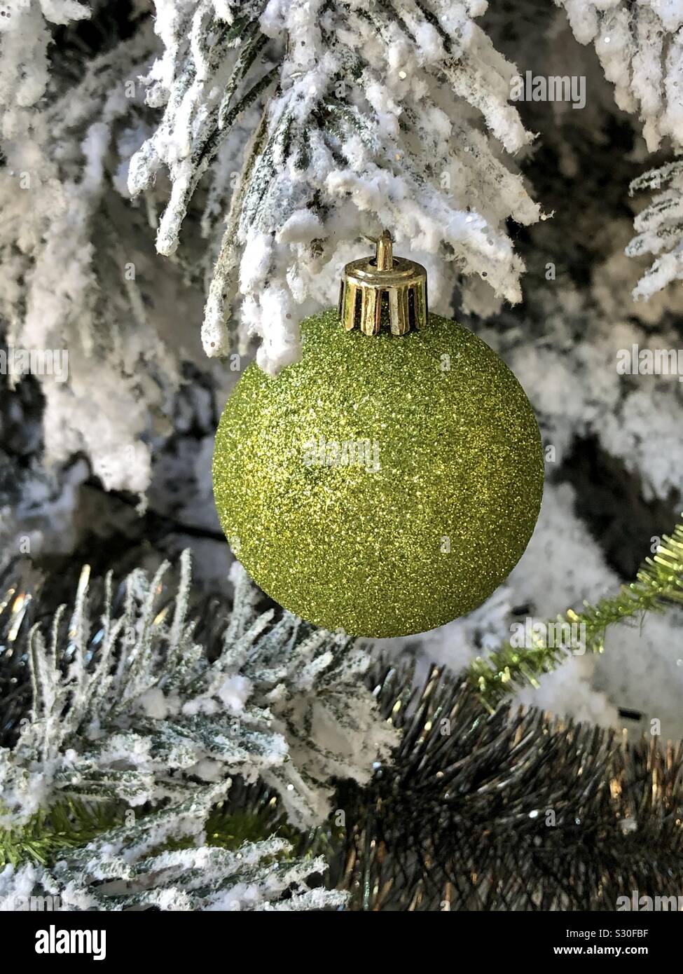 White Xmas tree decorated with with green hanging ornament. Stock Photo