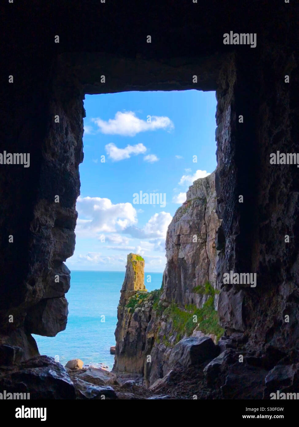 Looking out at the Celtic Sea from the interior of St. Govan’s Chapel,  St. Govan’s Head, Bosherston in the Pembrokeshire Coast National Park, Dyfed, Wales. Stock Photo