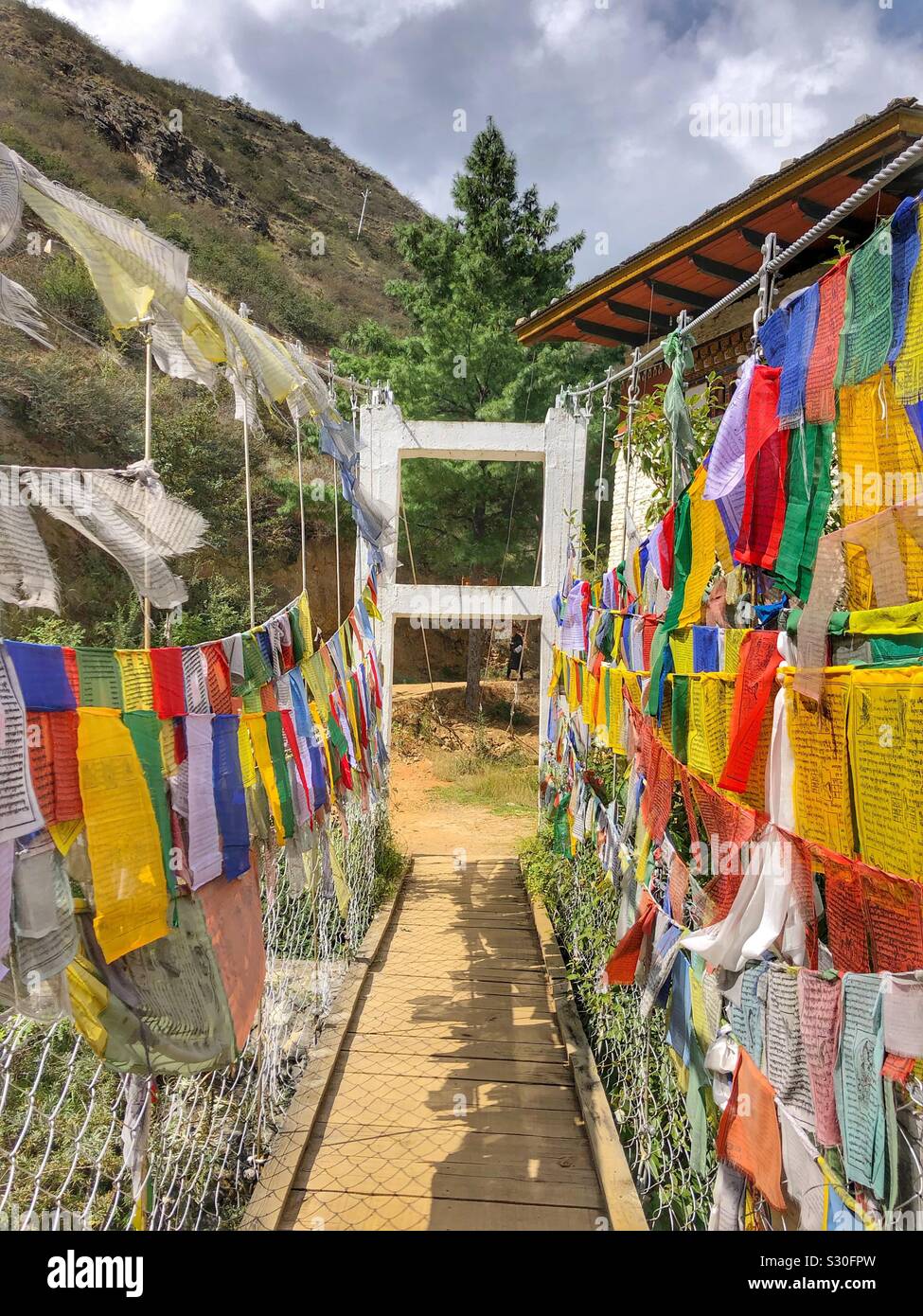 Prayer flags hang on a bridge in Bhutan. Stock Photo