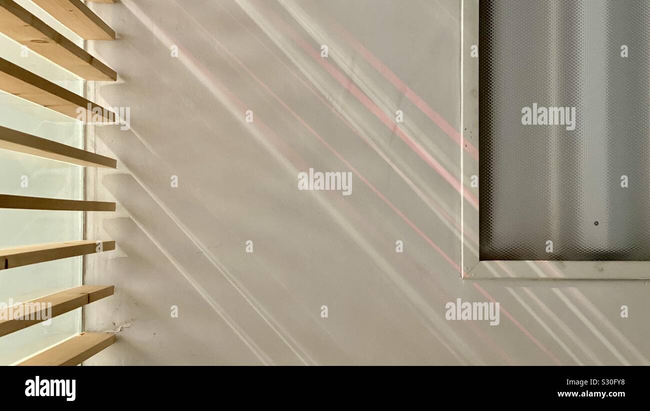 Pattern of colorful sunlight on ceiling, created by refraction through blinds and window treatment. - Smartphone Captured Stock Image