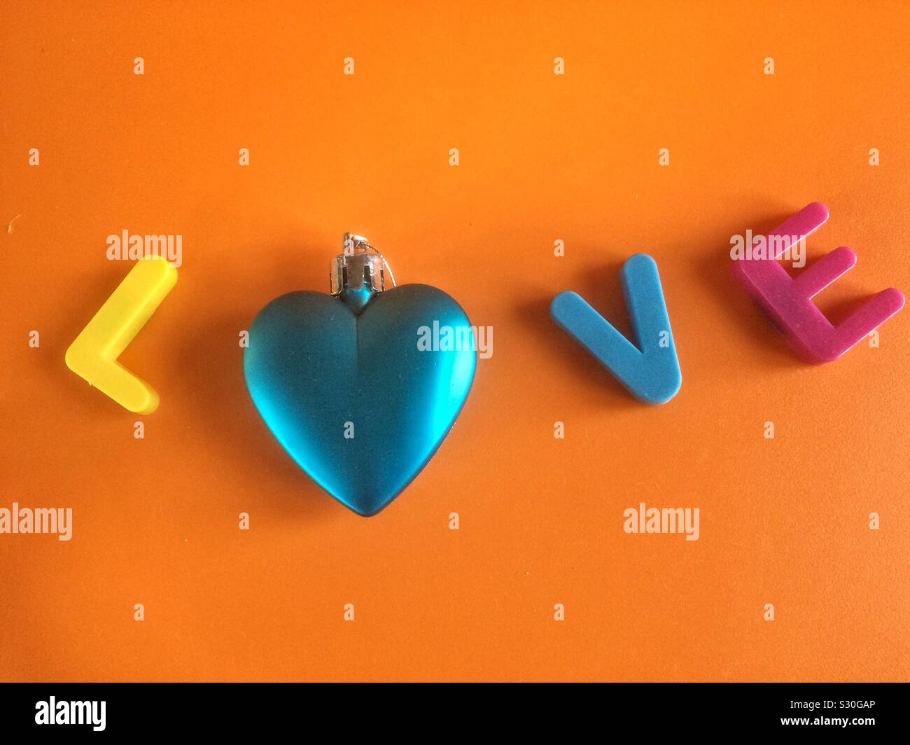 Word love close-up made with colorful letters and shiny blue heart ...