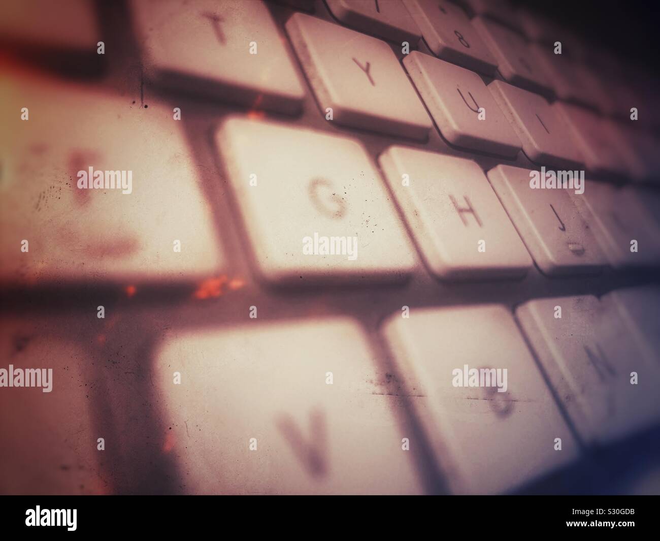 Grungy close up of Apple computer keyboard showing some of the keys at an angle. - Smartphone Captured Stock Image