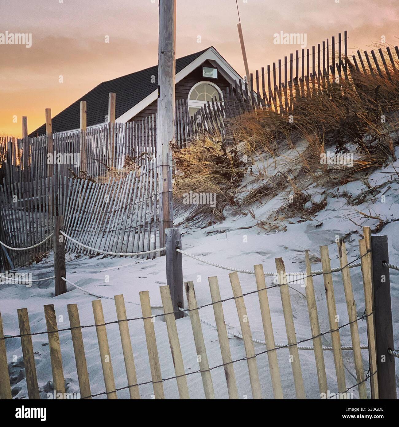 Looking past fences towards a house on Mayflower Beach, Dennis, Cape Cod, Massachusetts, United States - Smartphone Captured Stock Image