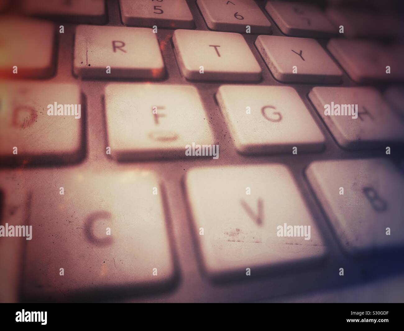 Grungy close up of Apple computer keyboard showing some of the keys at an angle. - Smartphone Captured Stock Image