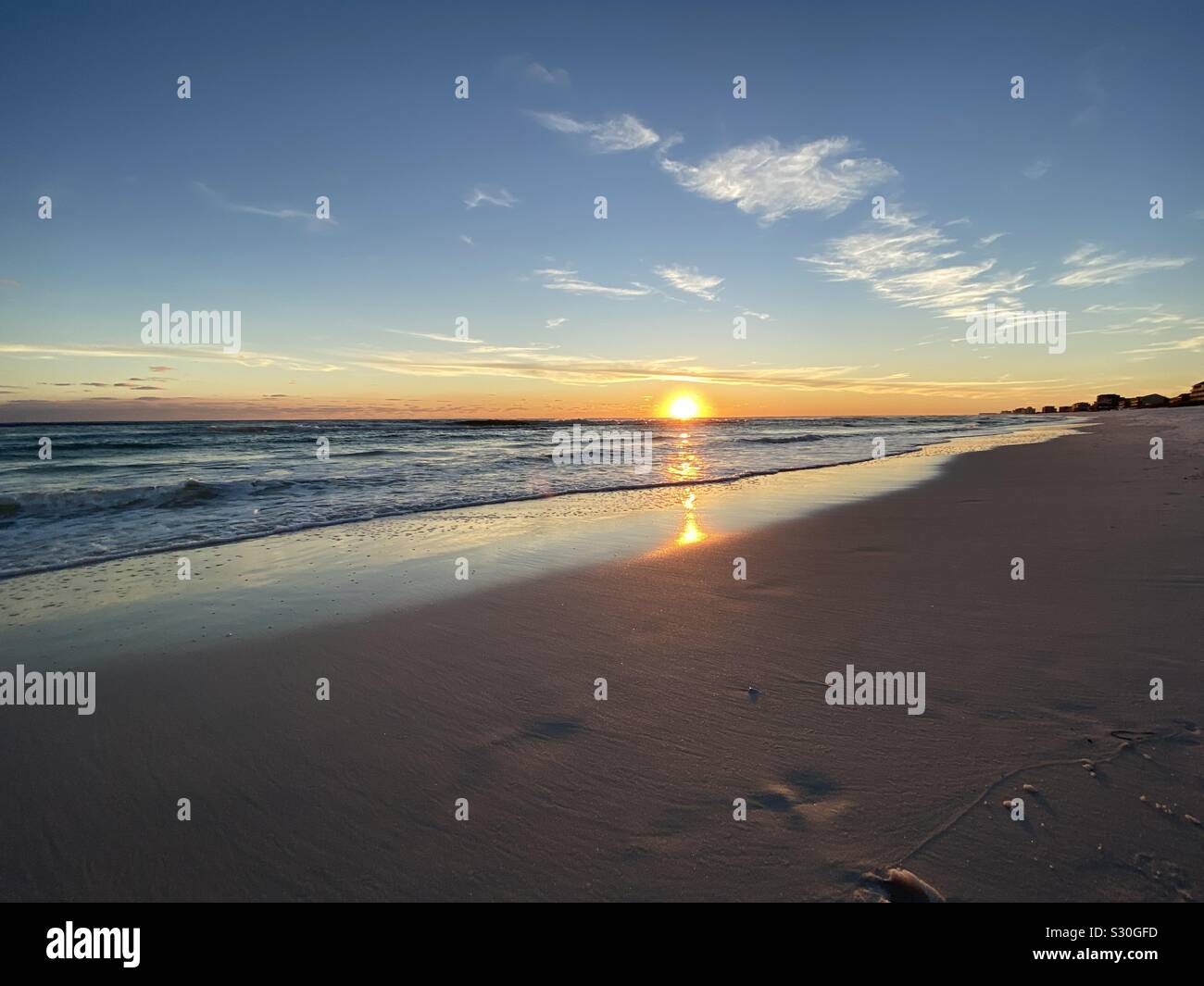 Golden beach sunset with color reflections on the sand - Smartphone Captured Stock Image