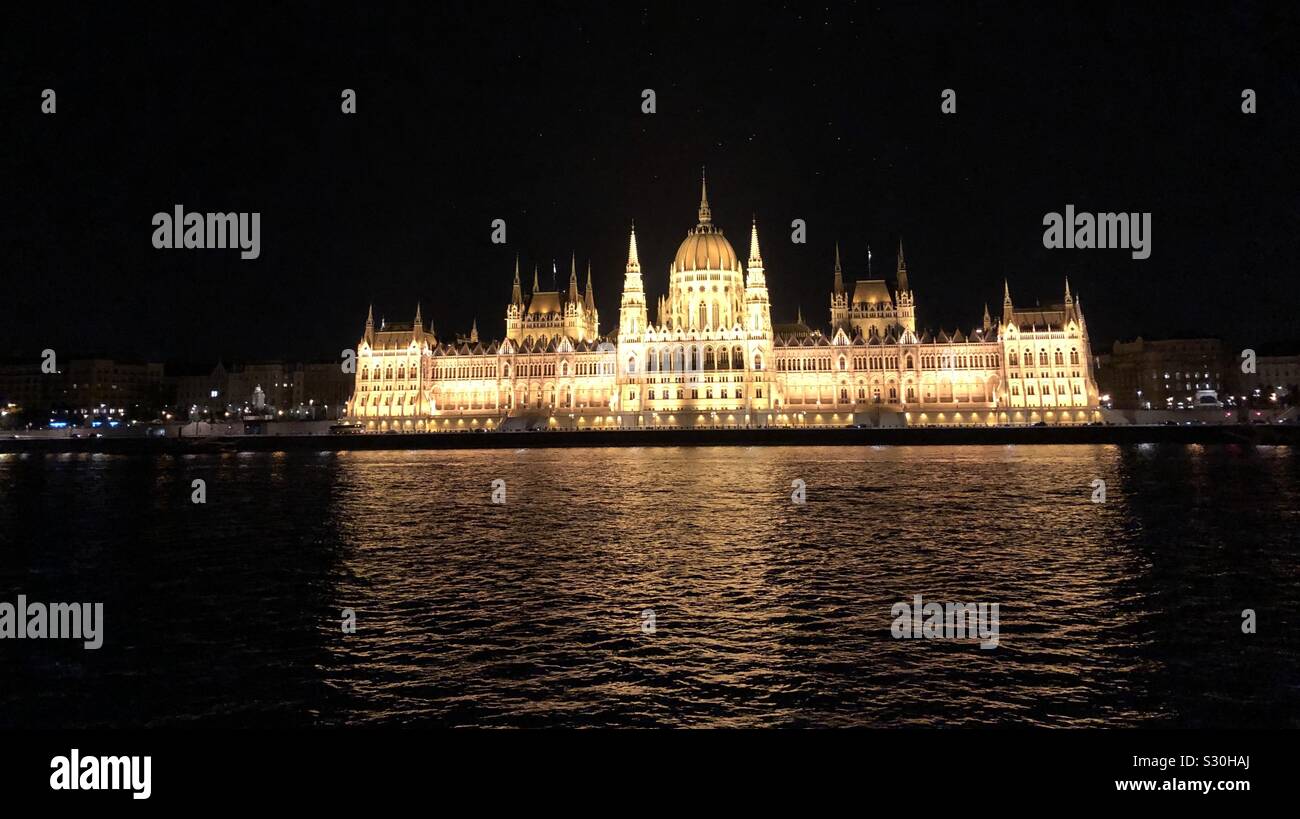 The parliament building lit up at night from the Danube River in Budapest, Hungary. - Smartphone Captured Stock Image