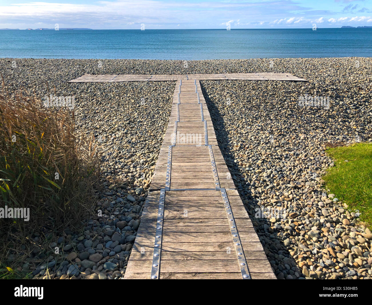 Wooden boardwalk over the pebbles at Newgale Beach, Pembrokeshire, Wales in the Pembrokeshire Coast National Park. Stock Photo