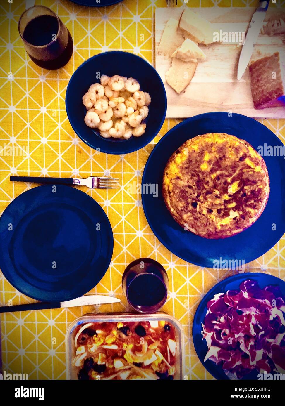Spanish homemade dinner with omelette, ajillo shrimp, iberico ham, and moje - Smartphone Captured Stock Image