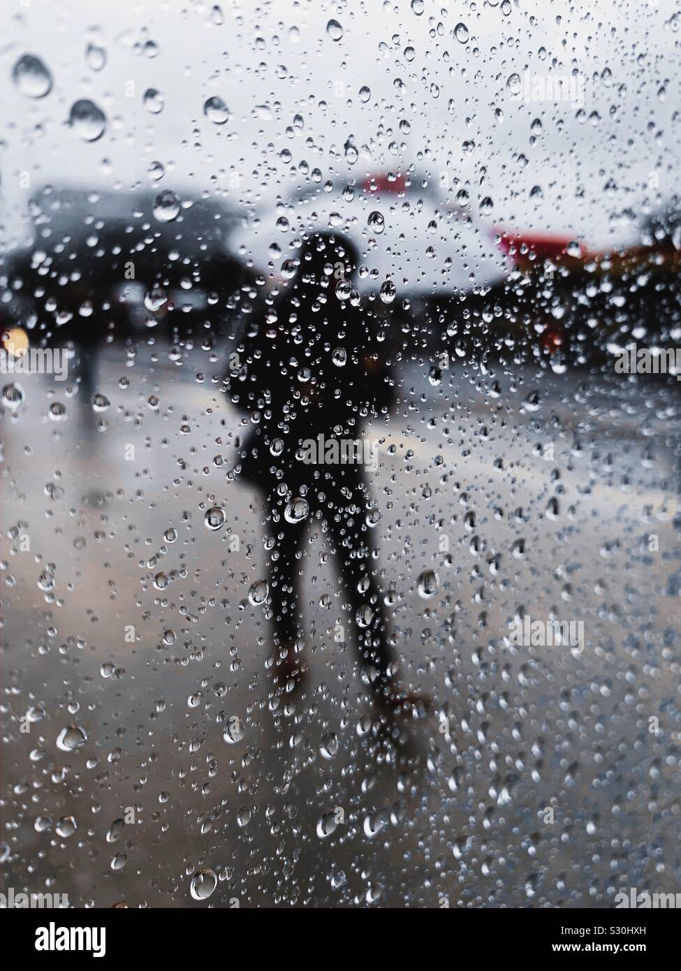 Person with an umbrella during a rainy day. Stock Photo