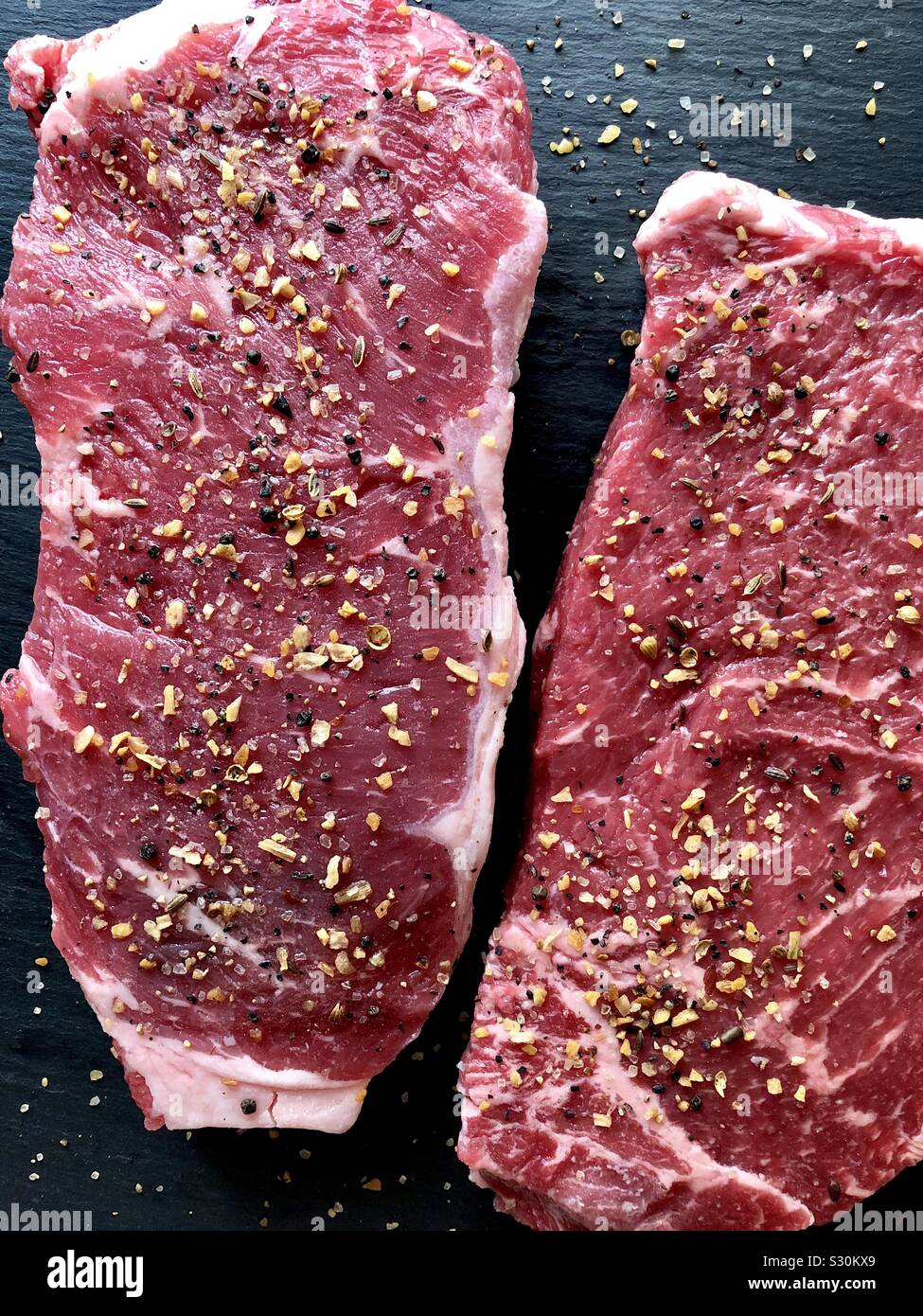 Uncooked, seasoned New York strip steaks Stock Photo