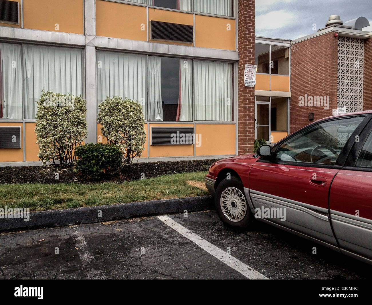 Janky car parked outside cheap motel. Baltimore, Maryland, USA. 2013