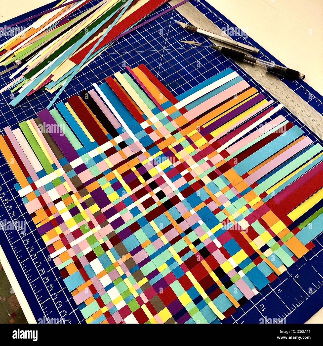 Craftwork with coloured paper strips woven together. - Smartphone Captured Stock Image