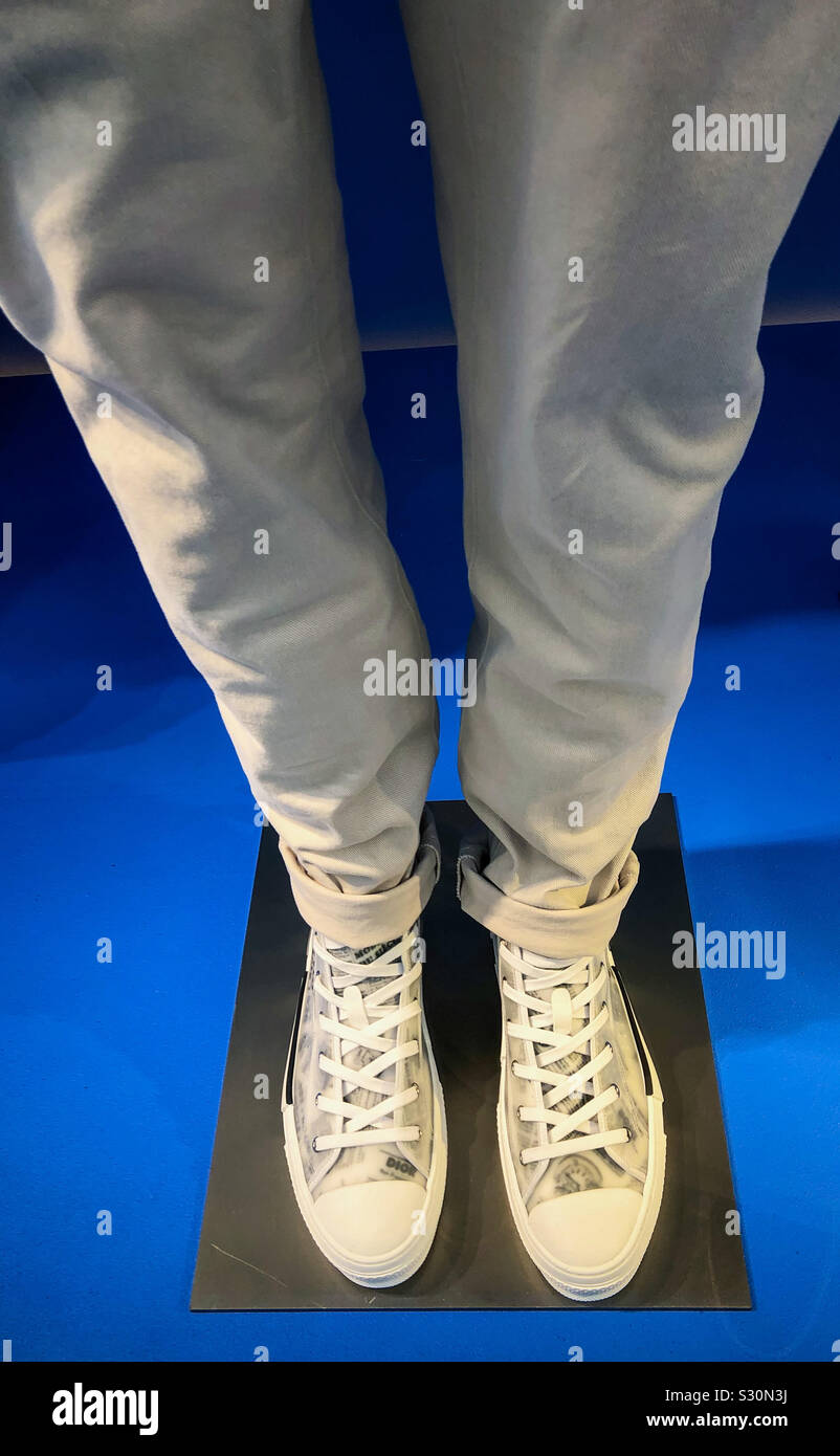 Christian Dior store window display showing detail if mannequin in white trousers and white designer high top shoes, Bond Street, London, UK Stock Photo