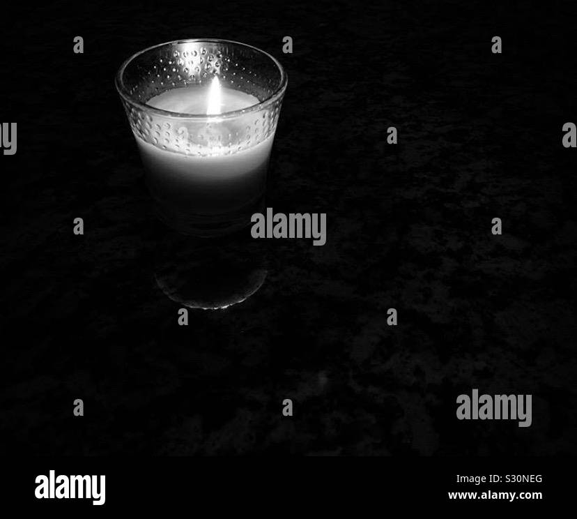Candle burning in a dark room Stock Photo Alamy