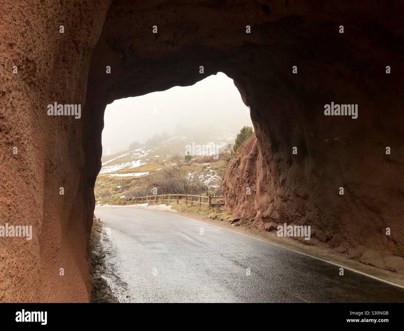 Stone arch over roadway in Red Rocks Park and Amphitheater with winter fog Stock Photo
