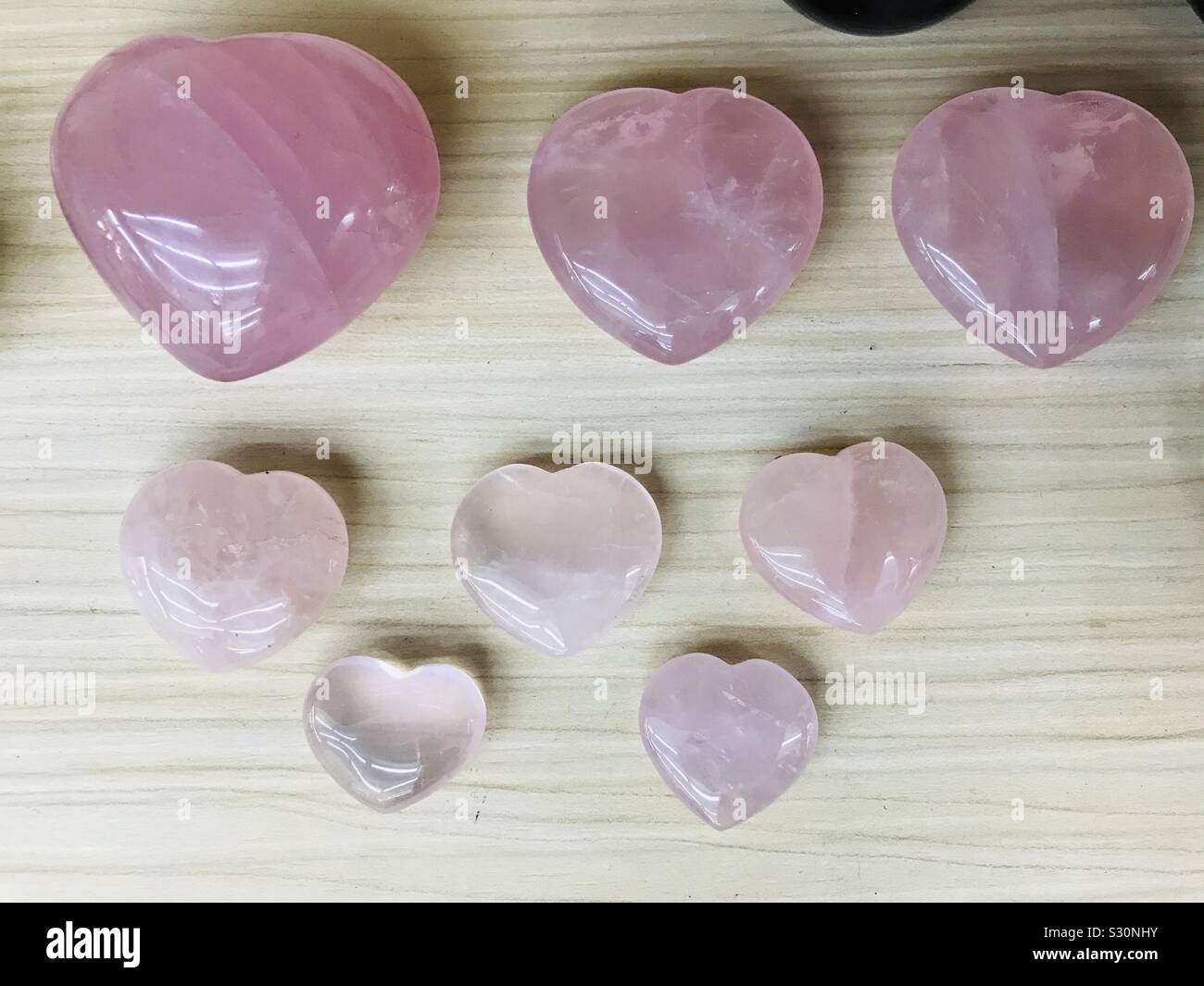 Feng Shui Powerful baby pink crystals in heart shape from big to small sizes, Extreme rocks & Fossils- stone hearts-pink glass heart-Rose quartz carved in heart shape,natural rose healing crystal Love Stock Photo