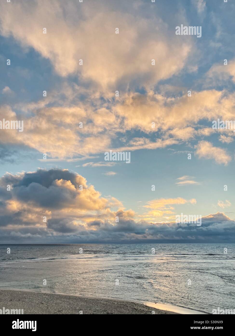 Warm glow of sunset on clouds at Surfers Point, Western Australia - Smartphone Captured Stock Image