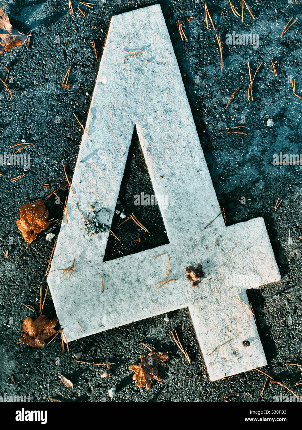 Giant white number 4 on ground with autumn leaves - Smartphone Captured Stock Image