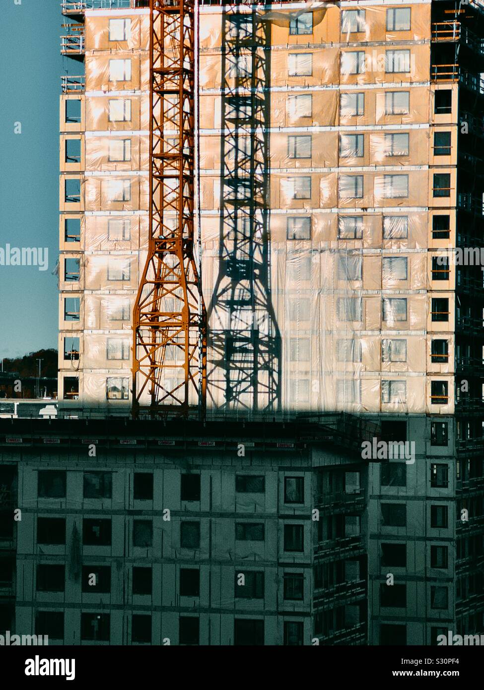 Shadow of metal tower on construction site of new apartments, Stockholm Stock Photo