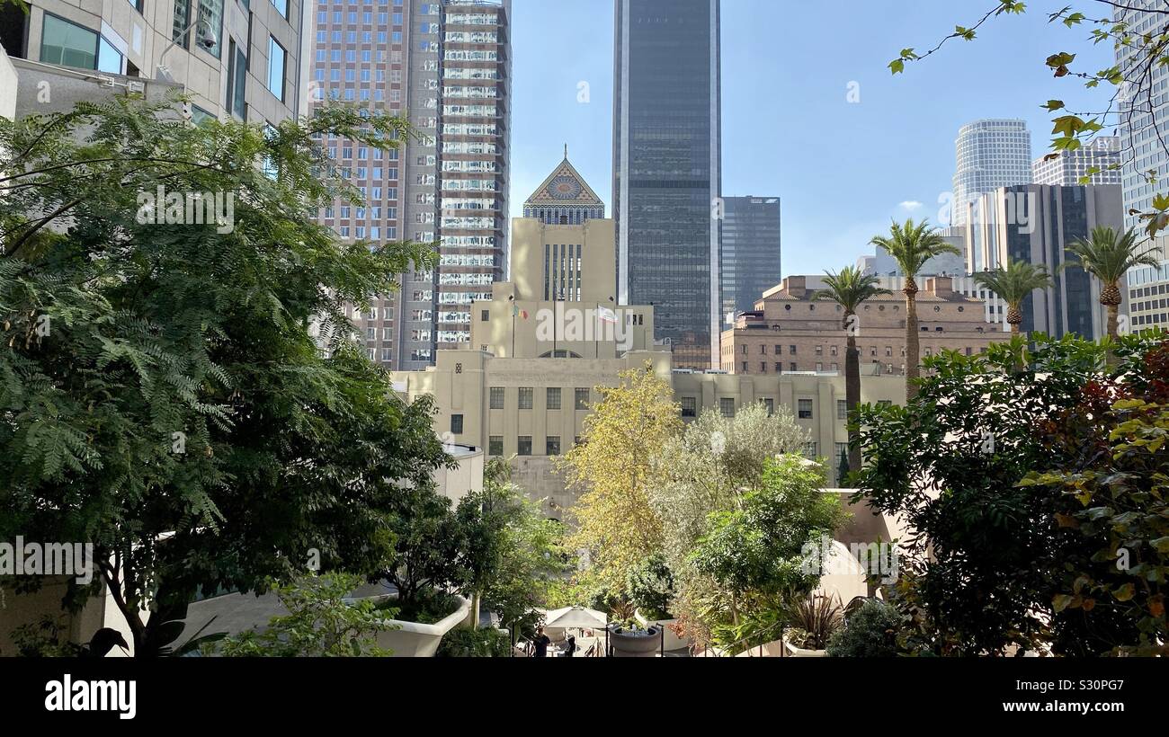 LOS ANGELES, CA, NOV 2019: central branch of Los Angeles Public Library surrounded by skyscrapers in Downtown, seen through trees next to the US Bank Tower Stock Photo