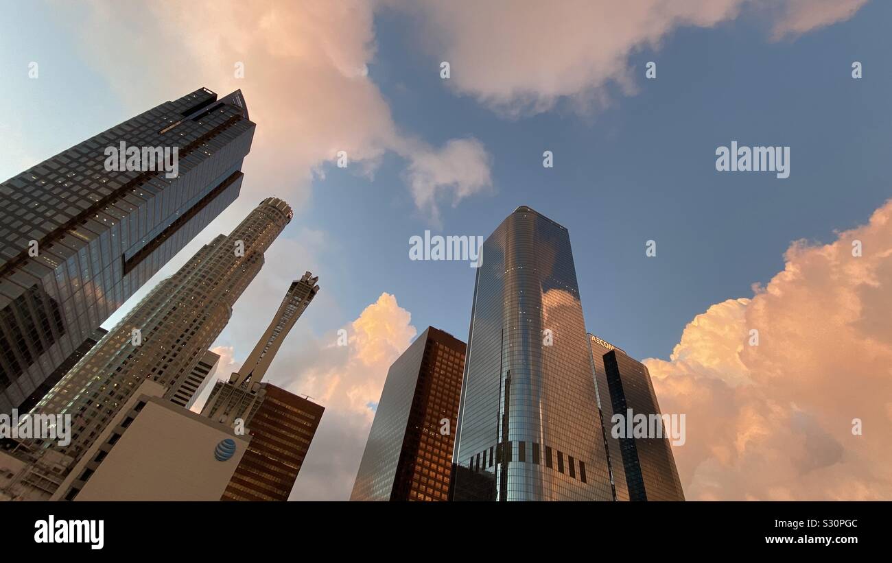 LOS ANGELES, CA, NOV 2019: wide lens view, looking up at US Bank Tower and other skyscrapers at sunset, with copper orange clouds, in the Financial District of Downtown - Smartphone Captured Stock Image